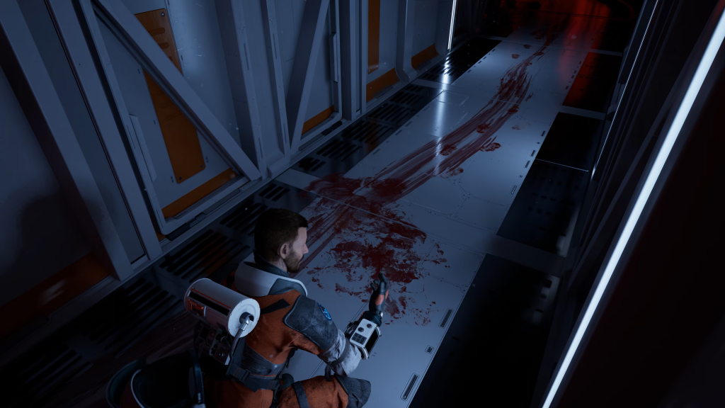 Thomas investigates a blood splatter on the floor of the spaceship. The blood streak suggests that a body was dragged away from where it fell.