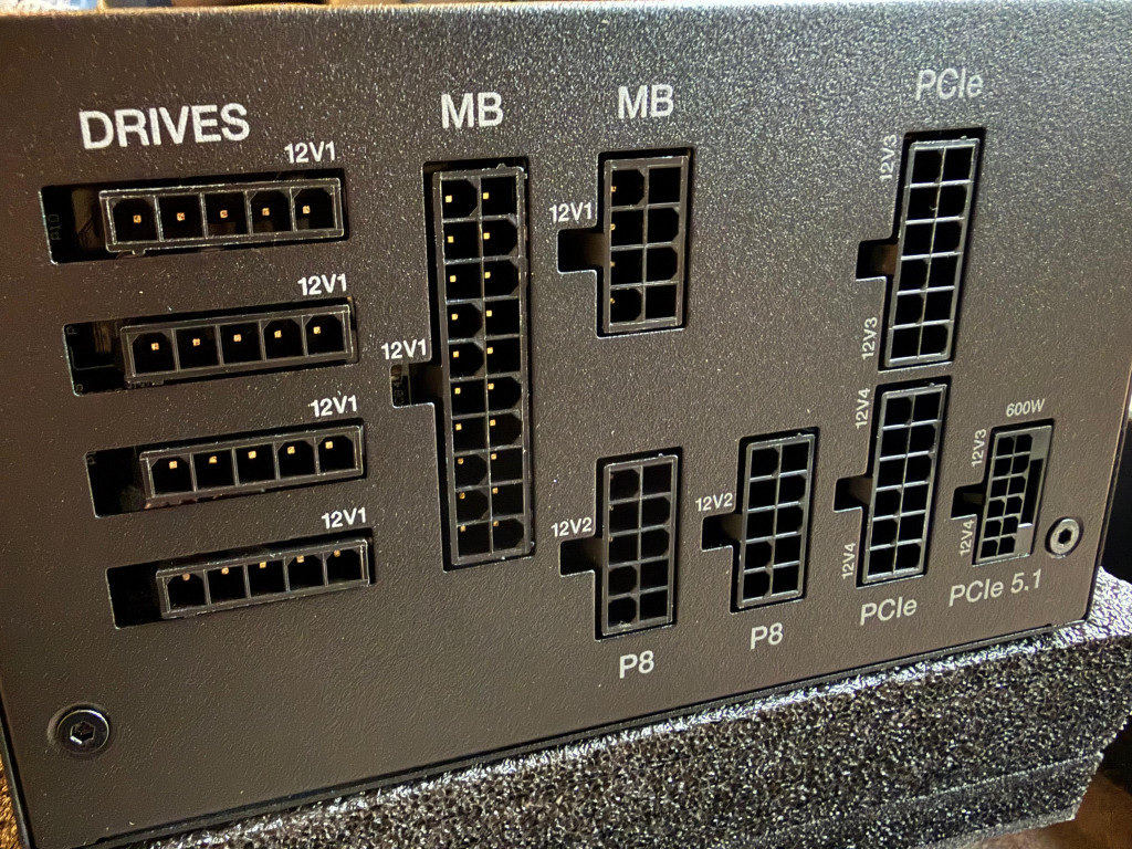 Close-up of a be quiet dark power 14 computer power supply ports labelled for drives, motherboard, and PCIe connections. The panel is metallic with a technical, organized feel.