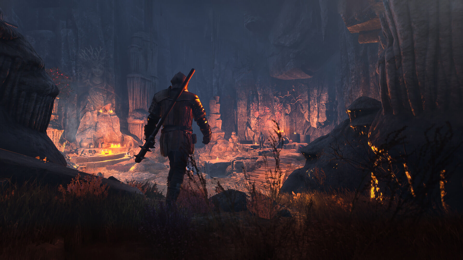 A character walks through a strange cave with man-made stone carvings. The area is dimly lit by candles.