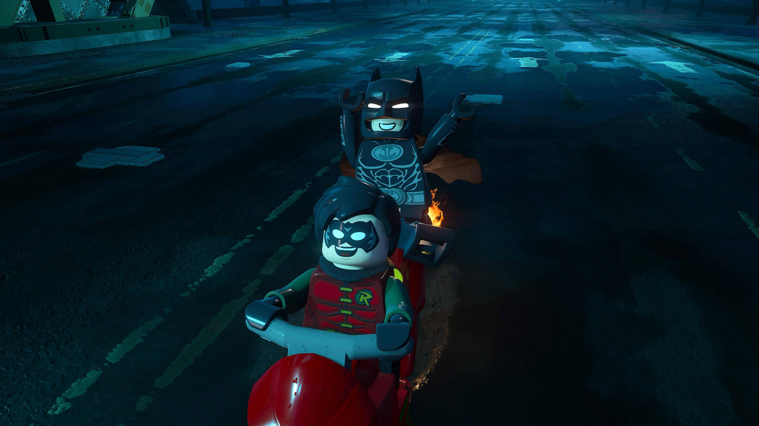 screenshot from the game showing robin and batman riding a motorcycle smiling