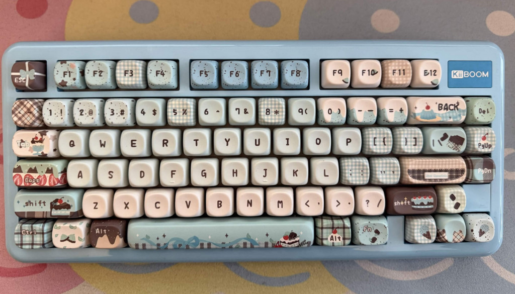 Compact kiiboom phantom 81 lite blue mechanical keyboard with dessert-themed keycaps on a playful gummy bear patterned desk mat.