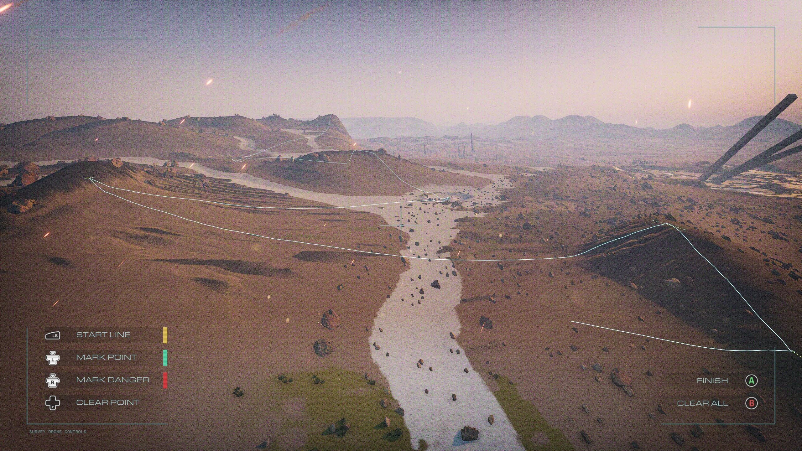 Alt text: A desert-like landscape with rocky terrain and hills, overlaid with a digital race or survey track marked by colored lines and icons.