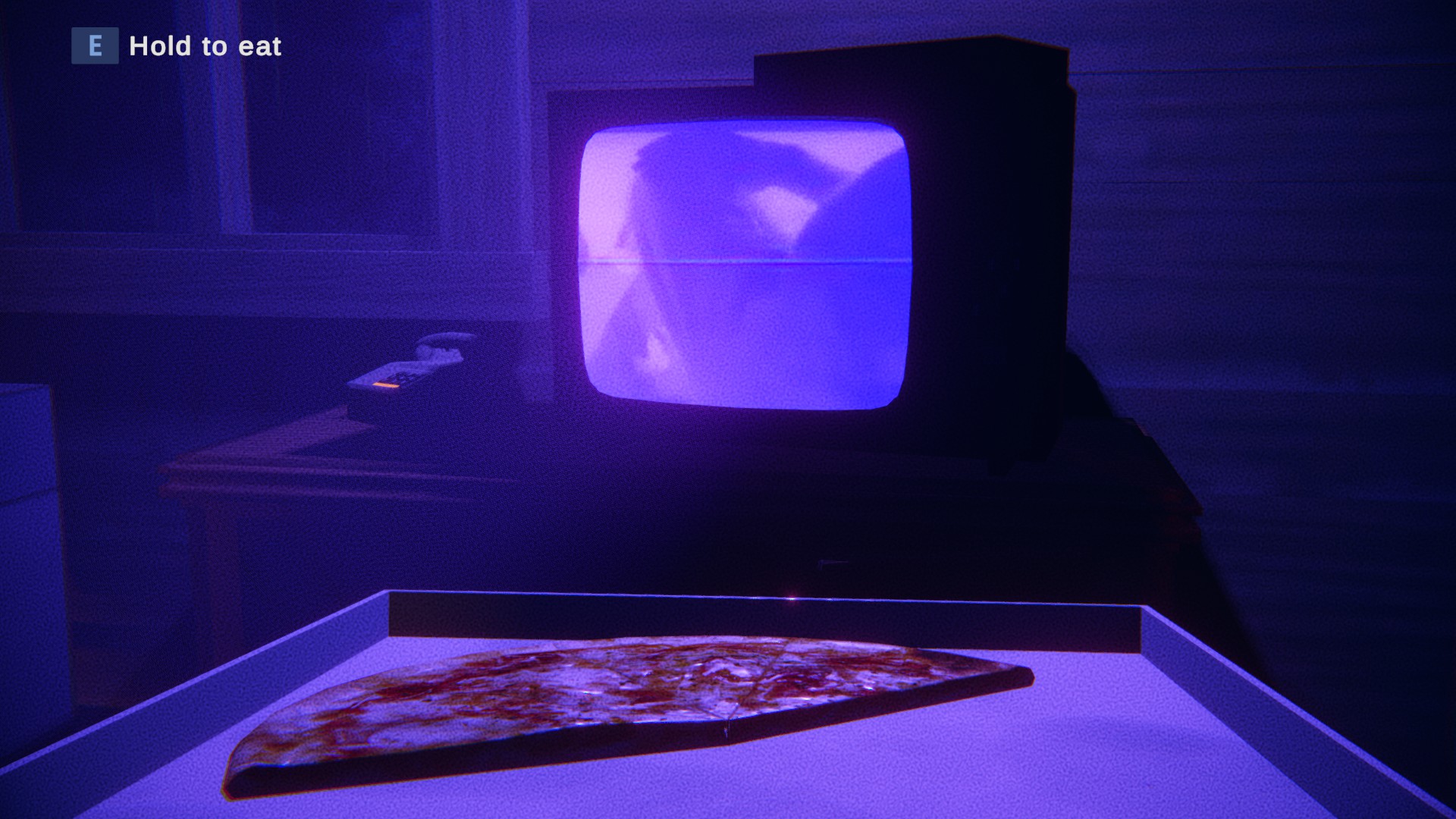 The player is watching tv that is illuminating purple. In front of them is a pizza box with a couple of slices left. In the top right it says E hold to eat. 