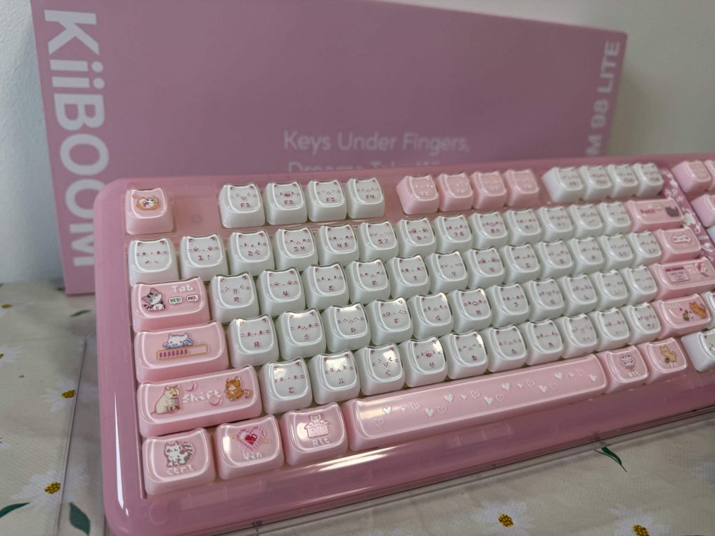 KiiBOOM Phantom 98 Lite pink and white mechanical keyboard with cute cat-themed keycaps and a pink KiiBOOM box in the background.