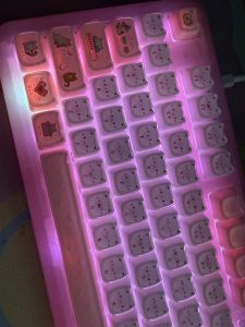 KiiBOOM Phantom 98 Lite pink backlit mechanical keyboard with cute cat face keycaps and additional cartoon character key designs on some keys.