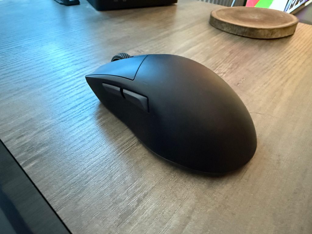 The Bequiet Dark Perk Ergo mouse in black, positioned beside a keyboard, highlighting its modern and ergonomic shape.
