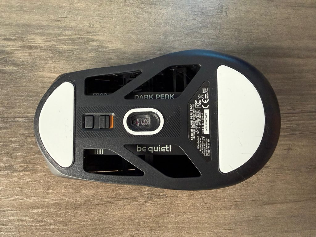 Black and white Bequiet Dark Perk Ergo mouse viewed from underneath, highlighting its stylish design and ergonomic shape.