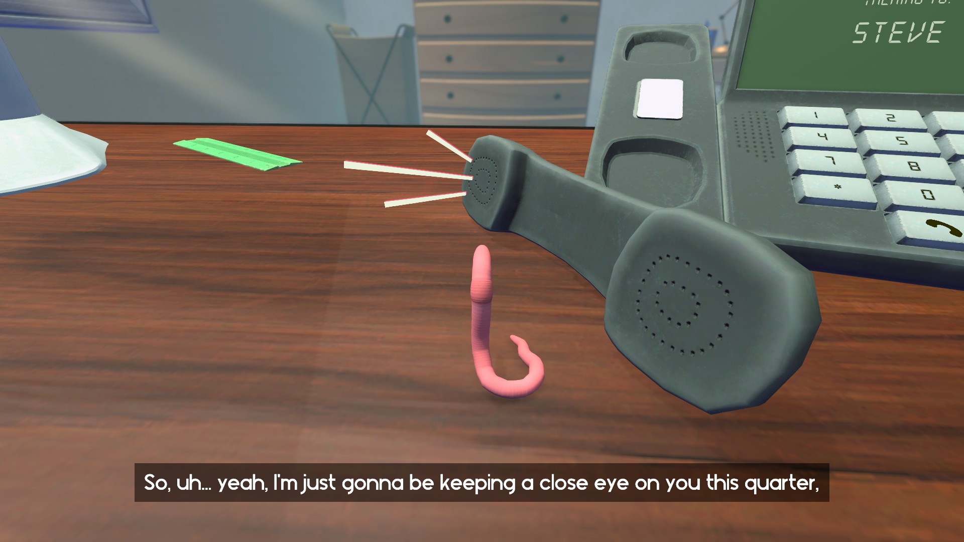 A bulky gray desk phone sits on a wooden counter beside a pink hook-shaped object and green paper; the subtitle gives the scene a quirky tone.