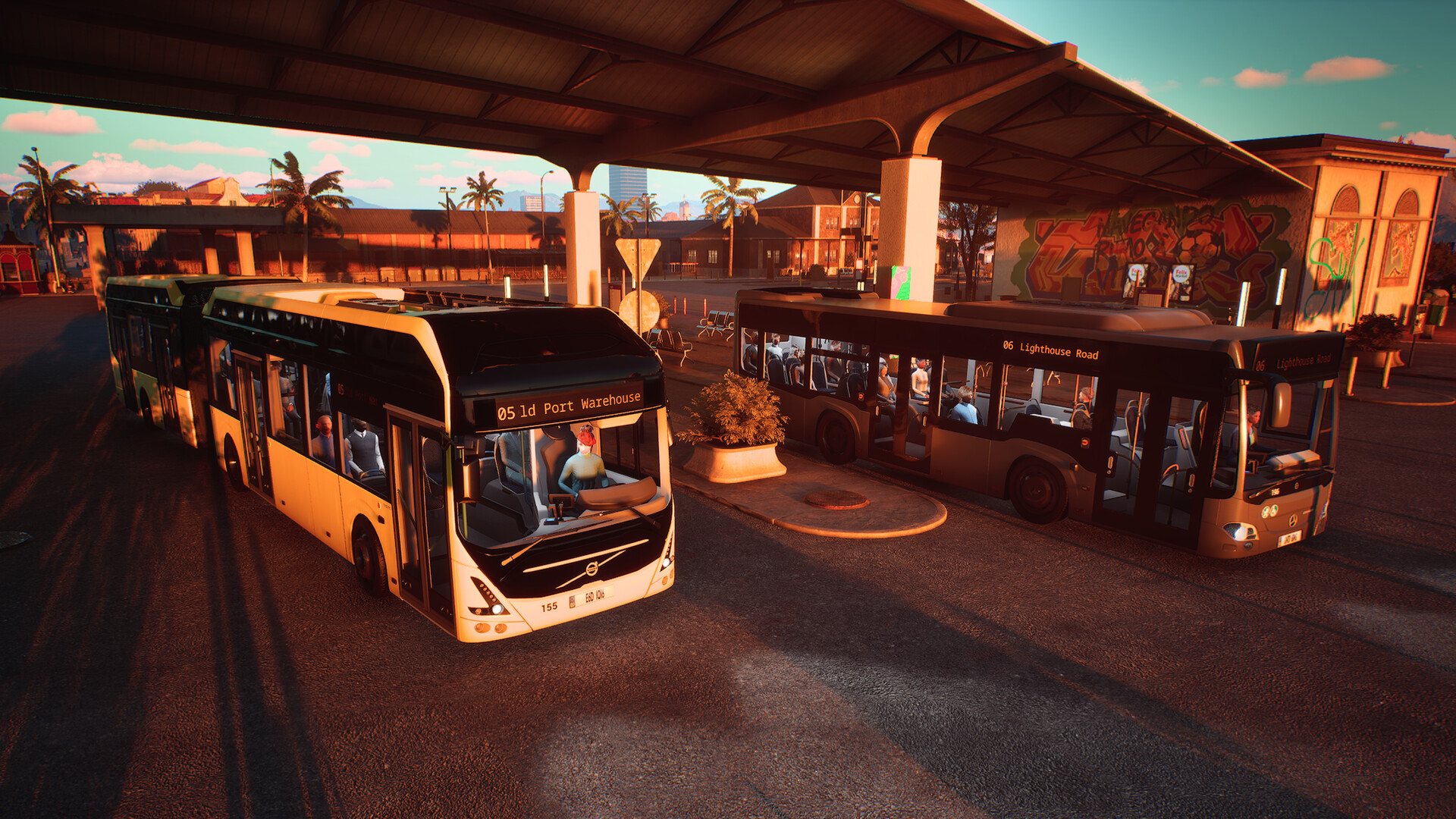 Two buses leaving a bus station. The sun is setting, casting an orange flow over the scene.