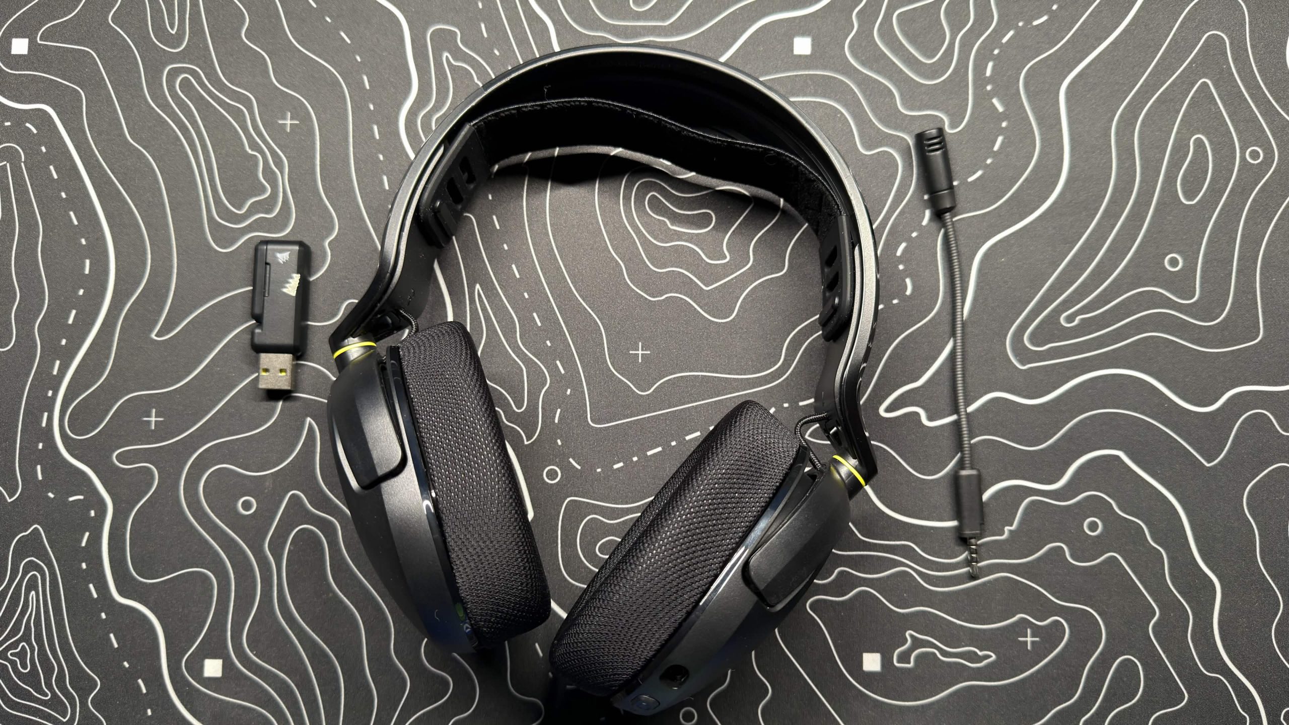 image of the corsair hs35 headset with the dongle and microphone on a desk