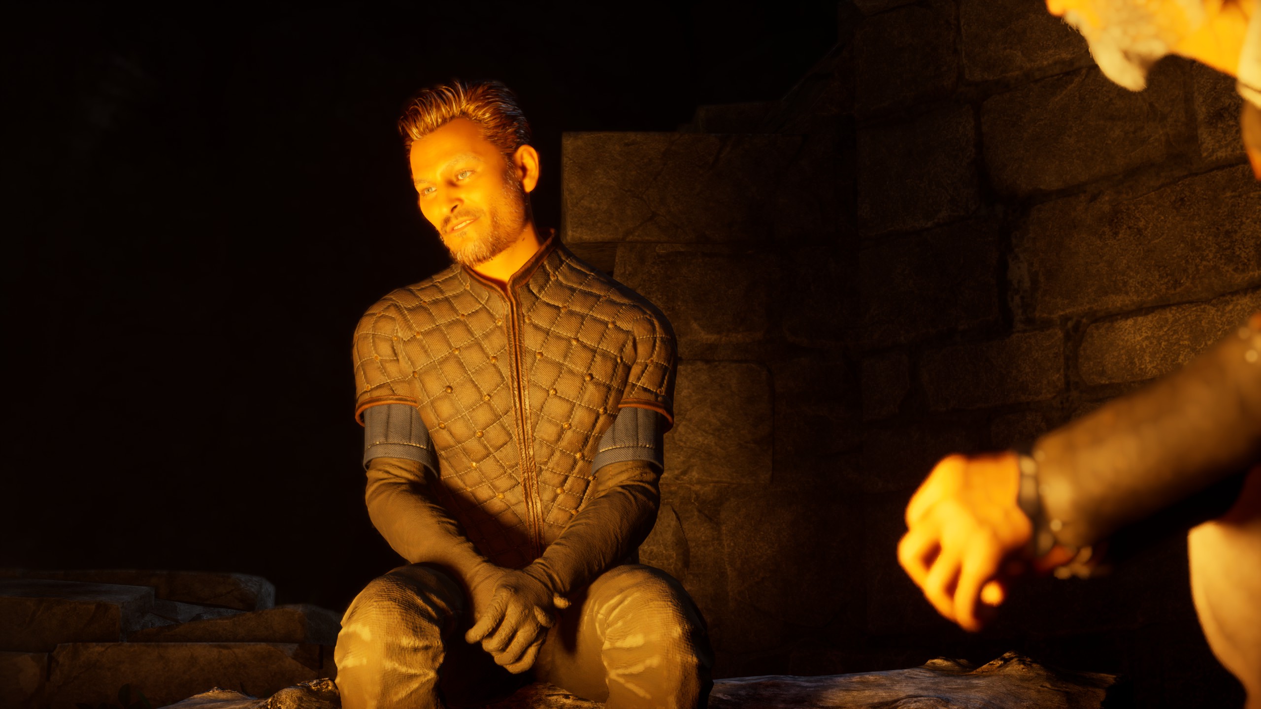 A bearded man in a quilted jacket sits beside a glowing campfire inside a dark stone chamber.